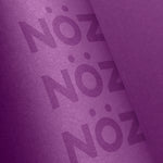 Load image into Gallery viewer, Close-up of a Nöz reef-safe sunscreen stick in purple.
