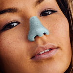 Load image into Gallery viewer, A girl wearing Nöz reef-safe sunscreen in blue on her nose.
